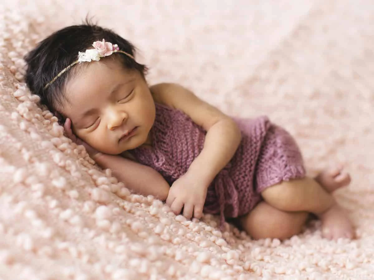 Sleeping newborn pink blanket retouching before